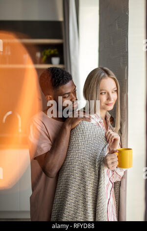 Loving black African young man hugs his caucasian wife. Stock Photo