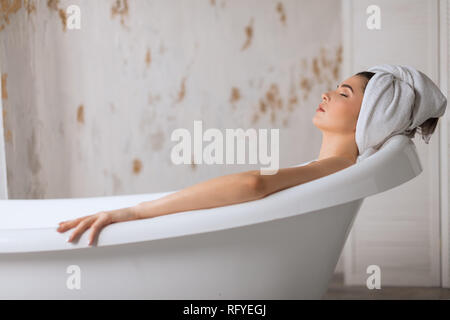 Relaxed young woman laying in bathtub Stock Photo