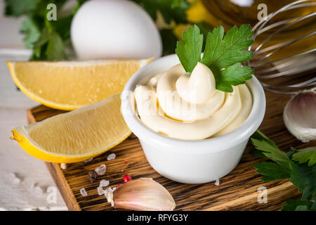 Mayonnaise sauce and ingredients on white. Close up. Stock Photo
