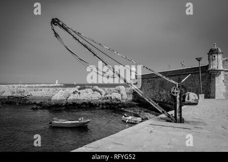 Black and White photo of a small dock and boat at Forte da Ponta da Bandeira, Portugal. Stock Photo