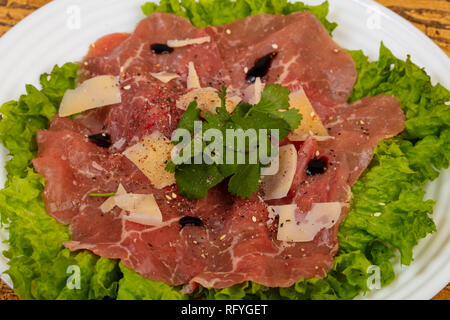 Beef carpaccio with parmesan cheese and salad leaves Stock Photo