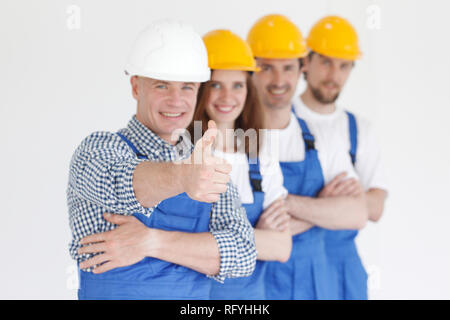 Group portrait of construction workers standing in a row and smiling Stock Photo