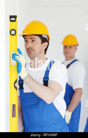 Team of workmen align wall using tools Stock Photo