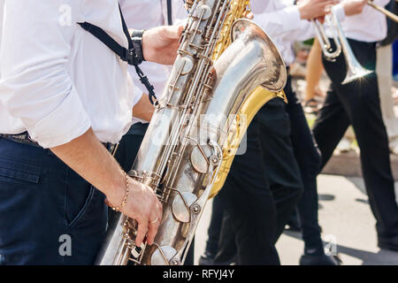 saxophonist playing at a jazz festival in a city park on sunny summer day Stock Photo