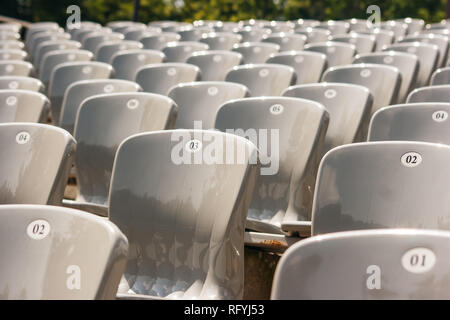 rows of plastic seats in the stadium outdoor on sunny summer day Stock Photo