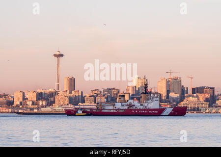 Coast Guard boat in Elliott Bay with sunset over downtown skyscrapers in Seattle, Washington, USA.