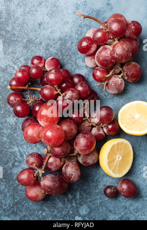 Red Grapes On Blue Background. Table Top View Stock Photo