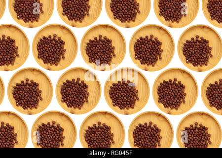 Peeled  hazelnut  in a wooden pine plate on a white isolated background. Row of bowls with hazelnut , top view. Peeled  hazelnut  pattern Stock Photo