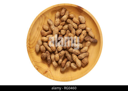 Unpeeled peanuts in a wooden pine plate on a white isolated background. Row of bowls with peanuts, top view.  Unpeeled peanuts pattern Stock Photo