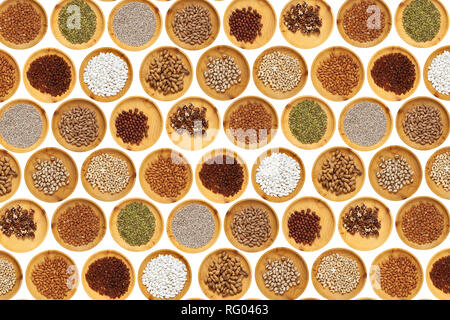 Raisins, cashews, apricot kernels, walnuts, sunflower seeds, hazelnuts, pumpkin seeds, peanuts and almonds in a wooden pine bowl stand in rows on a wh Stock Photo