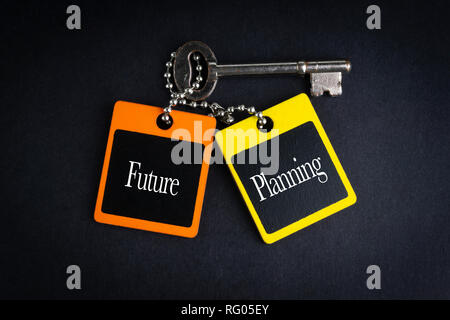 FUTURE PLANNING inscription written on wooden tag and key on black background with selective focus and crop fragment. Business and education concept Stock Photo