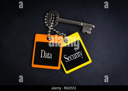 DATA SECURITY inscription written on wooden tag and key on black background with selective focus and crop fragment. Business and education concept Stock Photo