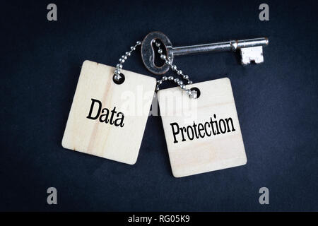DATA PROTECTION inscription written on wooden tag and key on black background with selective focus and crop fragment. Business and education concept Stock Photo