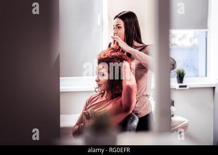 Nice young woman standing behind her client Stock Photo