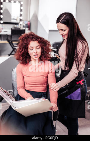 Nice young woman pointing at the catalogue picture Stock Photo