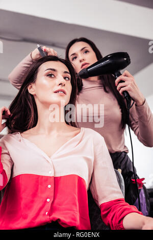 Nice pleasant woman touching her long hair Stock Photo