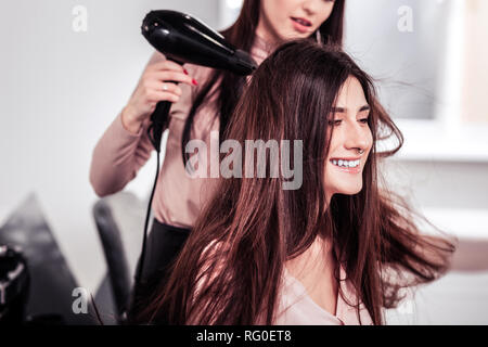 Delighted cheerful woman being in the hairdresser salon Stock Photo