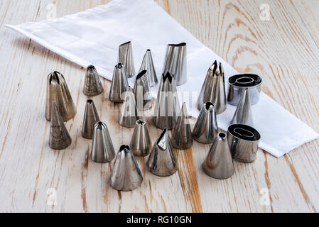 Set of stainless steel piping nozzles, with a piping bag. Fondant decorating tools. Stock Photo