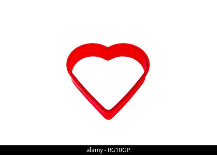 Red plastic heart shaped cookie cutter. Stock Photo