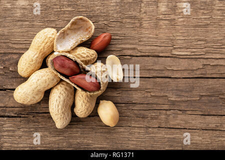 top view heap of peanuts in shell on wooden background Stock Photo