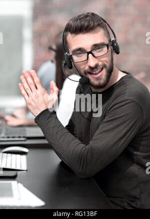 close up.modern man in a headset sitting at his Desk Stock Photo