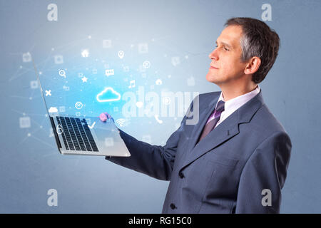 Man holding laptop projecting notifications, symbols and information based on cloud technology system Stock Photo