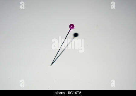 purple pin sticked in white background Stock Photo