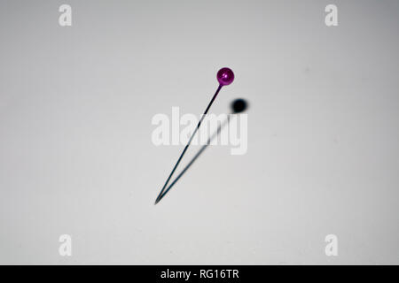 purple pin sticked in white background Stock Photo