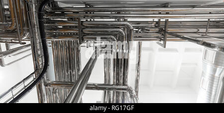 Steel pipelines and cables in factory interior as nuclear industry background concept Stock Photo