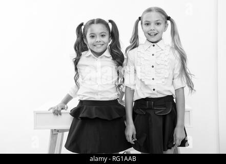 Example to follow. Schoolgirls with cute pony tails hairstyle. Best friends excellent pupils. Perfect schoolgirls with tidy fancy hair. School hairstyles ultimate top list. School fashion and style. Stock Photo