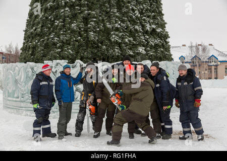 Group of builders of the ice town on the background of the Christmas tree Stock Photo