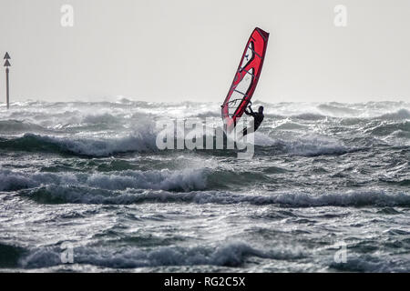 West Strand, West Wittering, Sussex. 27th January 2019. Gale force winds along the south coast today. Windsurfers taking on the conditions at West Wittering beach in West Sussex. Credit: james jagger/Alamy Live News Stock Photo