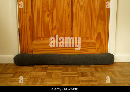 Draught excluder at the base of a door Stock Photo