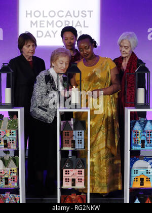 Actors (back row left to right) Dame Penelope Wilton, Nina Sosanya and Sheila Hancock join Holocaust survivor Mindu Hornick (front left) and Rwandan genocide survivor Chantal Uwamahoro (front right) in lighting a candle in memory of all victims of genocide at a Holocaust Memorial Day ceremony held the QEII Centre, Westminster, London. Stock Photo