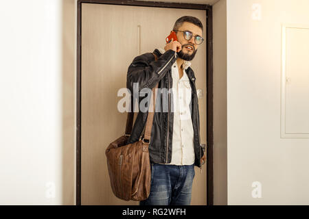 Handsome tall short-haired bearded man with a bag looking serious Stock Photo