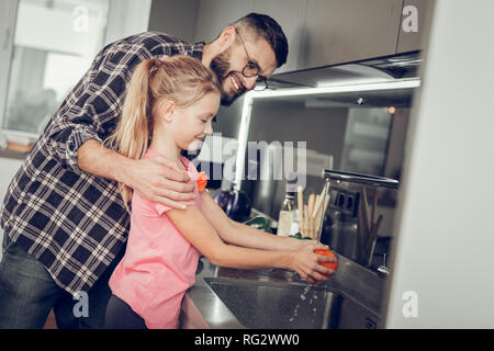 Long-haired pretty girl in a pink shirt spending a morning with her father Stock Photo