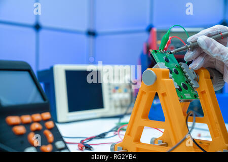 Fixing electronics PCB board in service /  workbench with electronics measuring instruments Stock Photo