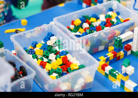 Close up of child's hands playing with colorful plastic bricks at the table. The first steps for the development of engineering type of thinking. Stock Photo