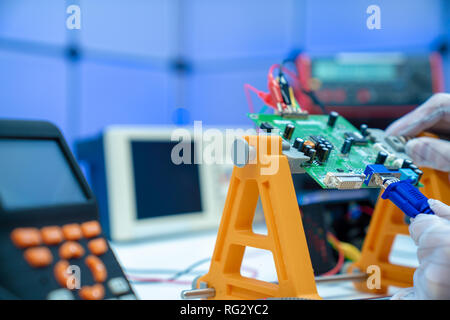 Fixing electronics PCB board in service /  workbench with electronics measuring instruments Stock Photo