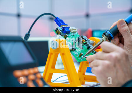 Fixing electronics PCB board in service /  workbench with electronics measuring instruments Stock Photo