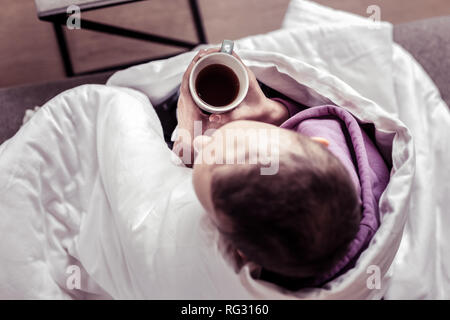 Upset female person being deep in her thoughts Stock Photo