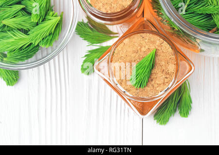 Homemade pine cough syrup for dry irritating throat coughs. Made from green young pine buds and honey.Alternative medicine concept on white wooden tab Stock Photo
