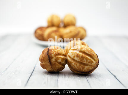 Cookies - nuts on a wooden table, on a background of blurred baking Stock Photo