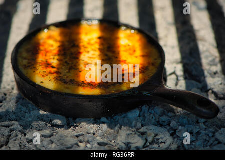Delicious Argentinian Provolone Yarn Cheese (Provoleta) that is cooked in a cast iron skillet over the embers and ashes, Buenos Aires, Argentina. Stock Photo