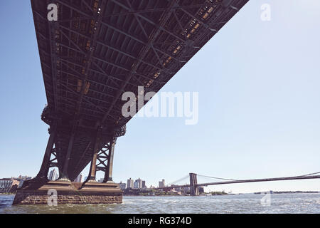 Under the Manhattan Bridge, retro toned picture with lens flare, New York, USA. Stock Photo