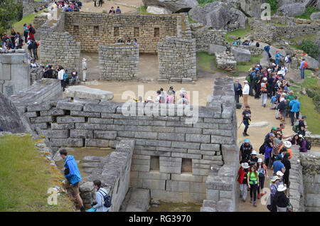 MACHU PICCHU / PERU, August 16, 2018: Tourists explore amid the ruins of Machu Picchu. Stock Photo