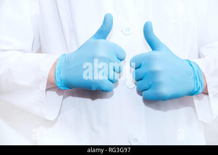 Hands of surgeon in blue medical glove showing Ok signs, isolated on a white background. Stock Photo