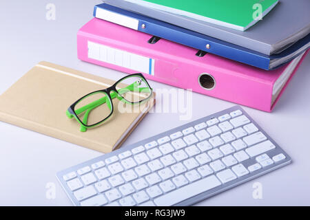 Office desk table with blank notebook, keyboard, other supplies and coffee cup. Top view with copy space Stock Photo