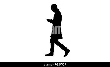 Full length portrait side view. Silhouette Male doctor walking and using mobile phone. Professional shot in 4K resolution. 004. You can use it e.g. in Stock Photo