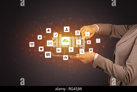 Female hand touching tablet with application icons above Stock Photo